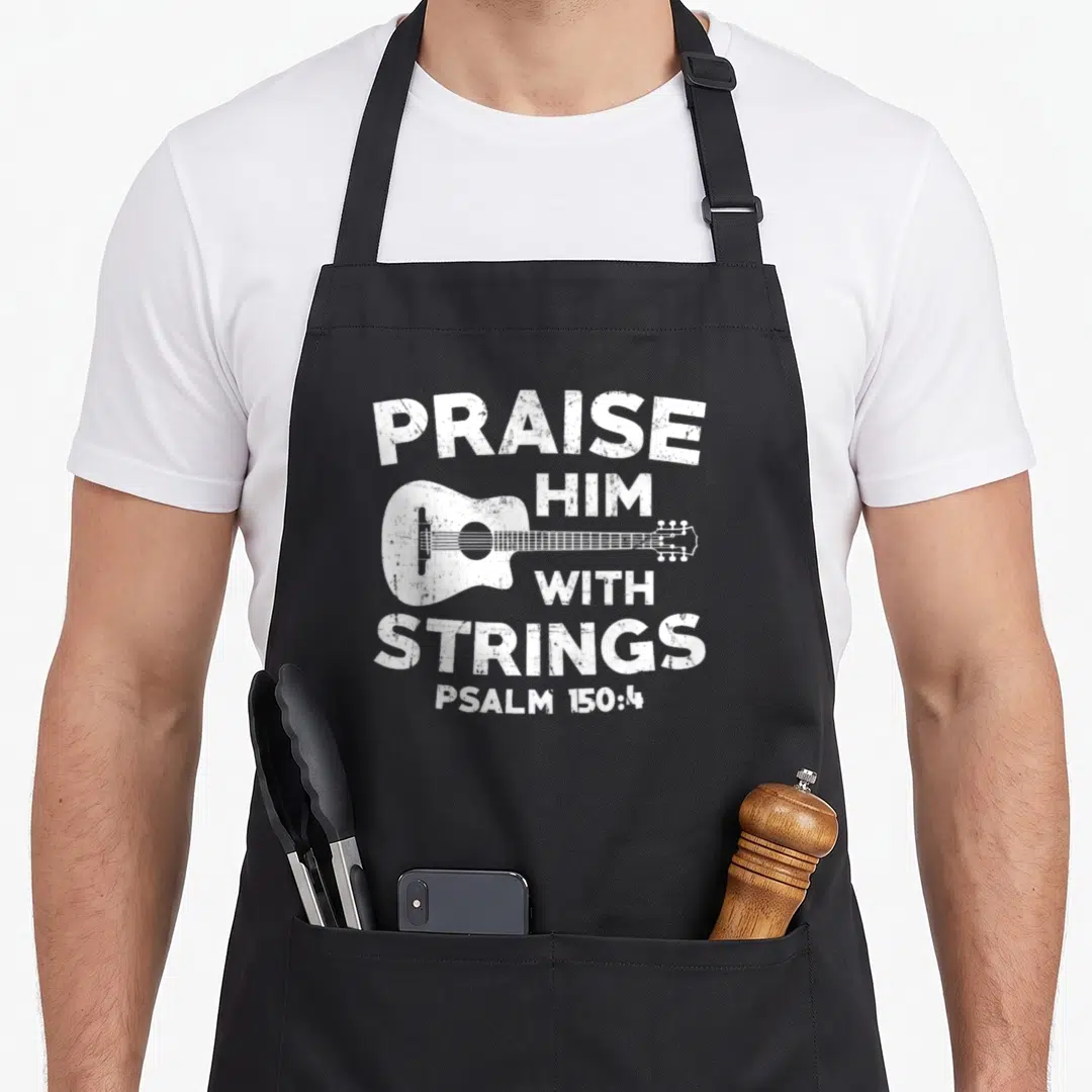 Music church christian apron - White distressed acoustic guitar with PRAISE HIM WITH STRINGS text and Psalm 150:4 — shown on a black cotton canvas apron against a white background