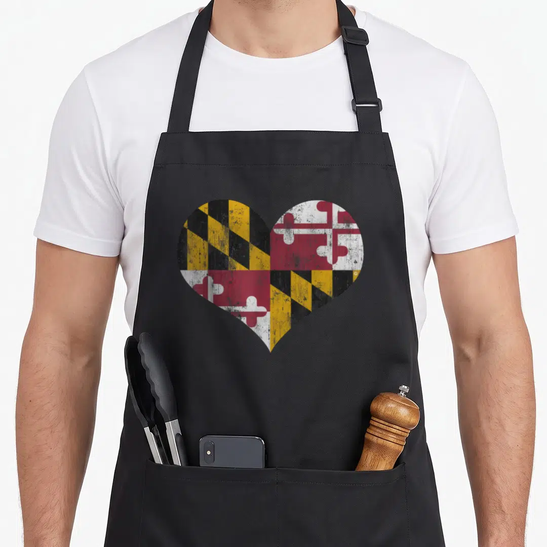 Flag maryland eastern apron - Distressed heart shape filled with Maryland flag yellow black red and white quadrants — shown on a black cotton canvas apron against a white background