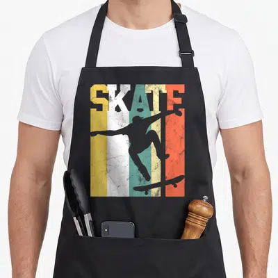 Skateboard best skater skateboarder accessories stuff apron - Retro SKATE text on yellow white teal orange grey stripes — shown on a black cotton canvas apron against a white background