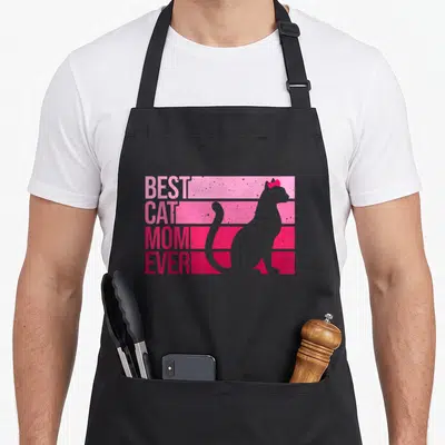 Animal kitten cat apron - Retro BEST CAT MOM EVER text stacked on pink stripes beside a grey cat silhouette with a red — shown on a black cotton canvas apron against a white background
