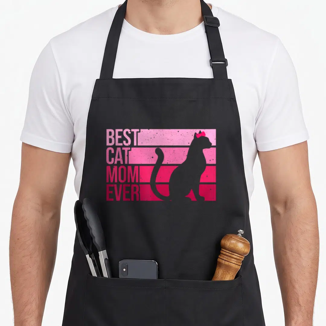Animal kitten cat apron - Retro BEST CAT MOM EVER text stacked on pink stripes beside a grey cat silhouette with a red — shown on a black cotton canvas apron against a white background