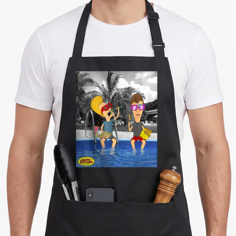 Lounging judge apron - Beavis and Butt-Head at pool with price tags on red and purple sunglasses — shown on a black cotton canvas apron against a white background