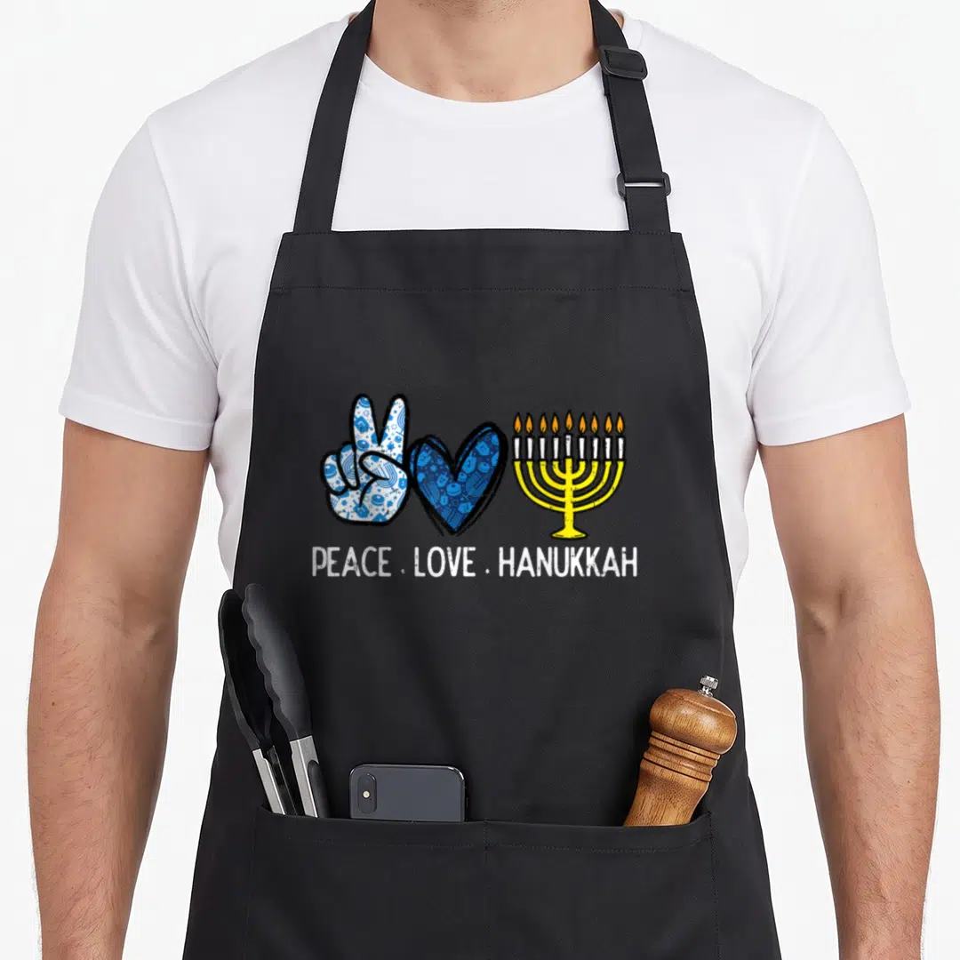 Peace hanukkah apron - Peace sign hand, heart, and menorah symbols with text PEACE LOVE HANUKKAH — shown on a black cotton canvas apron against a white background