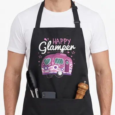 Glamper camping apron - Purple camper trailer with flowers and hearts under HAPPY Glamper text — shown on a black cotton canvas apron against a white background