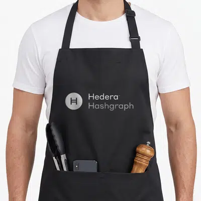 Hedera crypto apron - Circular H logo next to stacked Hedera and Hashgraph text — shown on a black cotton canvas apron against a white background