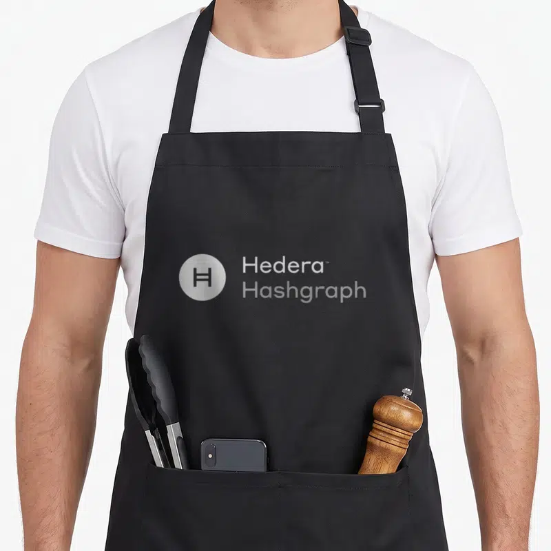 Hedera crypto apron - Circular H logo next to stacked Hedera and Hashgraph text — shown on a black cotton canvas apron against a white background