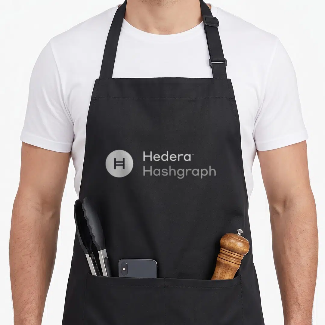 Hedera crypto apron - Circular H logo next to stacked Hedera and Hashgraph text — shown on a black cotton canvas apron against a white background