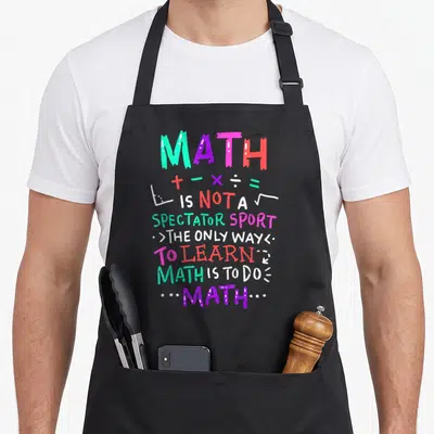 Mathematical teacher apron - Colorful stacked text reading math is not a spectator sport with arithmetic symbols — shown on a black cotton canvas apron against a white background