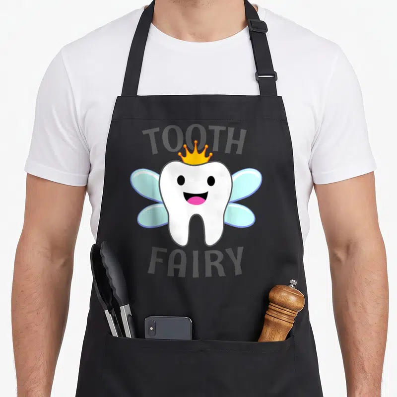 Tooth fairy halloween apron - Cartoon white tooth with blue wings and yellow crown between TOOTH and FAIRY text — shown on a black cotton canvas apron against a white background