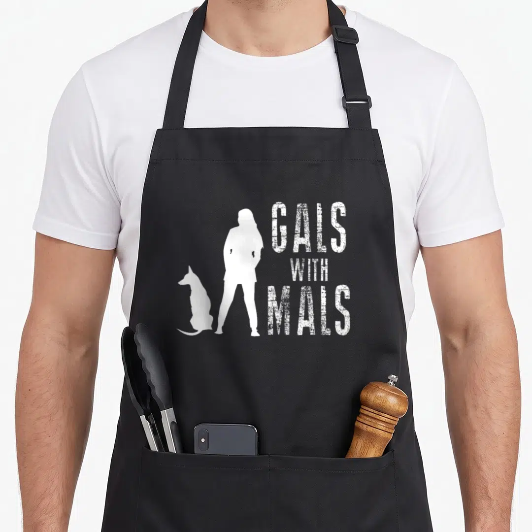 Gal malibu apron - White distressed GALS WITH MALS text beside standing woman and sitting dog silhouettes — shown on a black cotton canvas apron against a white background