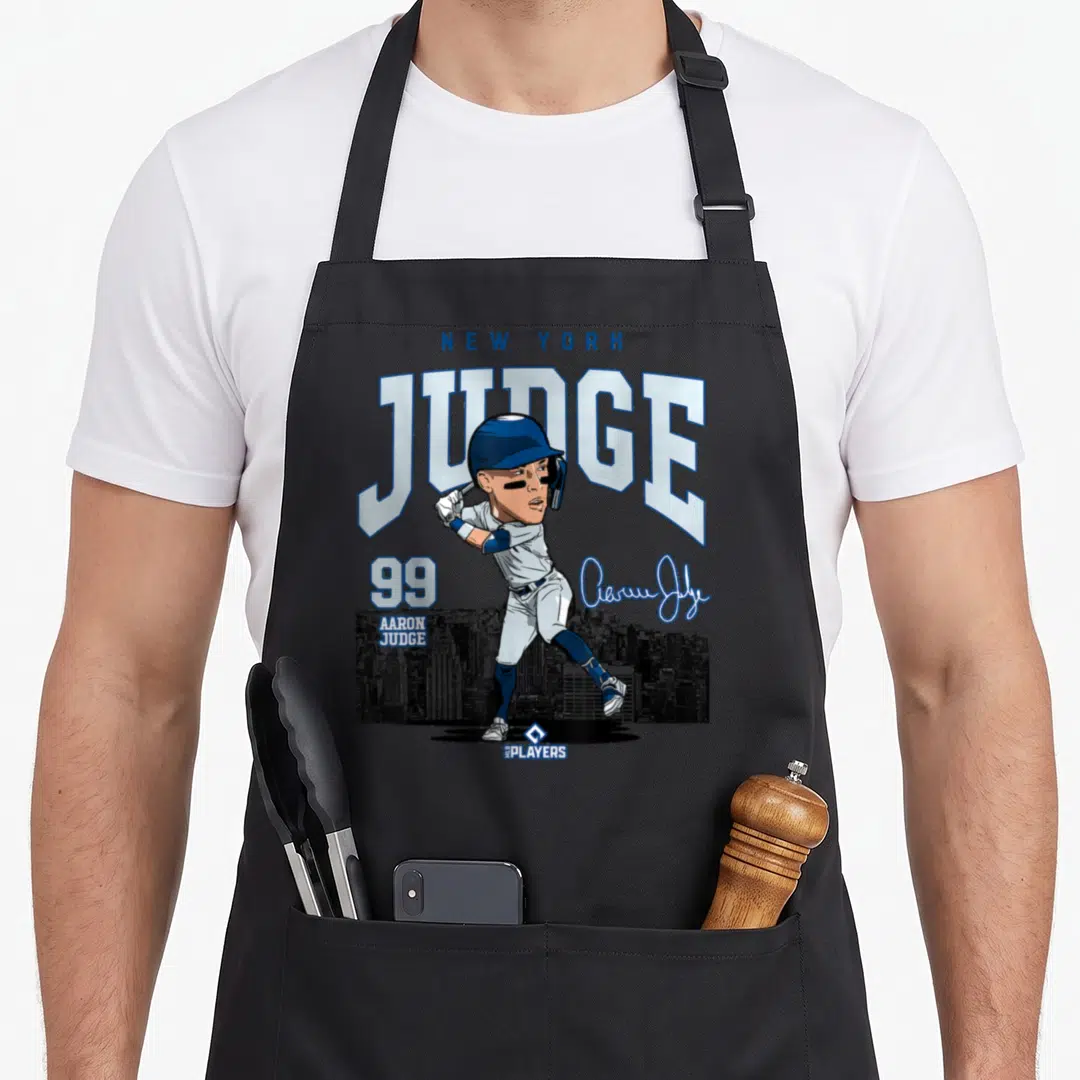 Mlbjud3005w new york apron - Cartoon baseball player JUDGE 99 with signature and skyline in blue white grey — shown on a black cotton canvas apron against a white background