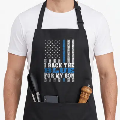 Blue proud dad and son aprons - Distressed flag with I BACK THE BLUE FOR MY SON text in blue and white — shown on a black cotton canvas apron against a white background