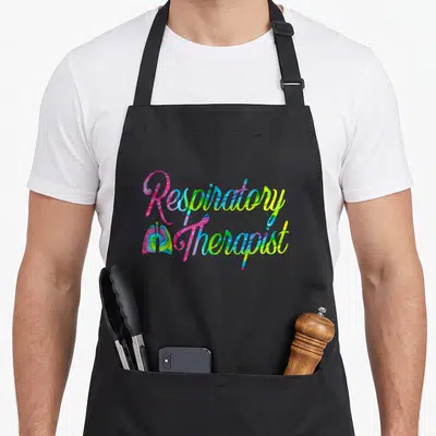 Respiratory tie-dye apron - Stacked Respiratory Therapist text in pink blue green and yellow tie-dye swirl pattern — shown on a black cotton canvas apron against a white background