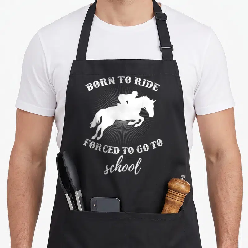 School horse apron - White distressed horse and rider silhouette with arched text over sunburst rays — shown on a black cotton canvas apron against a white background