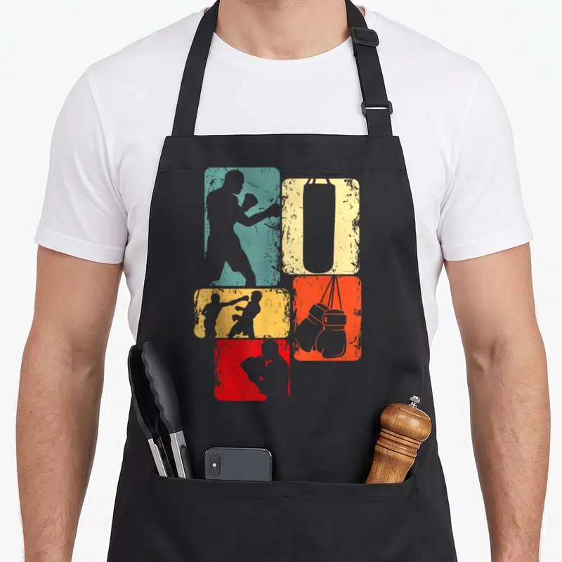 Boxer boxing apron - Four distressed teal, yellow, red, and grey rectangles with boxer, bag, and glove silhouettes — shown on a black cotton canvas apron against a white background