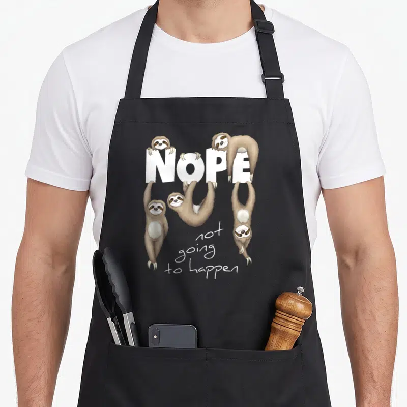 Nope sloth apron - Four cartoon sloths hanging on white NOPE letters with script text not going to happen below — shown on a black cotton canvas apron against a white background