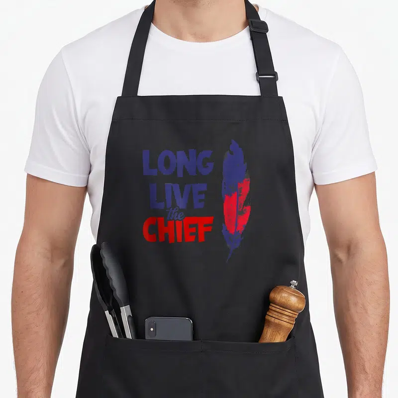 Live chiefs apron - Stacked Long Live The Chief text next to a blue and red distressed feather — shown on a black cotton canvas apron against a white background