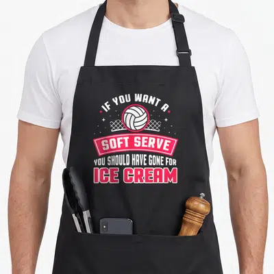 Player to serve man apron - IF YOU WANT A SOFT SERVE YOU SHOULD HAVE GONE FOR ICE CREAM with volleyball and net graphic — shown on a black cotton canvas apron against a white background