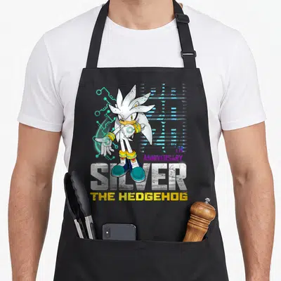 20th distressed apron - Silver the Hedgehog character standing over SILVER text with TH ANNIVERSARY in purple and yellow — shown on a black cotton canvas apron against a white background