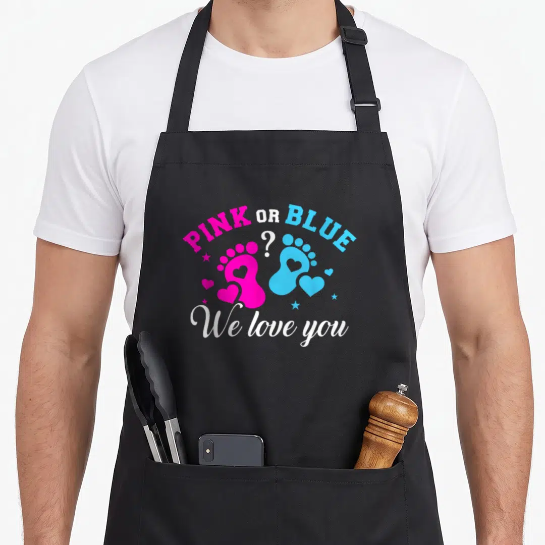 Gender shower apron - Pink and blue baby footprints with PINK OR BLUE text and hearts — shown on a black cotton canvas apron against a white background