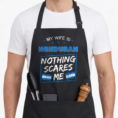 Honduran wife apron - Blue distressed text reading My Wife Is Honduran Nothing Scares Me with two Honduran flags — shown on a black cotton canvas apron against a white background
