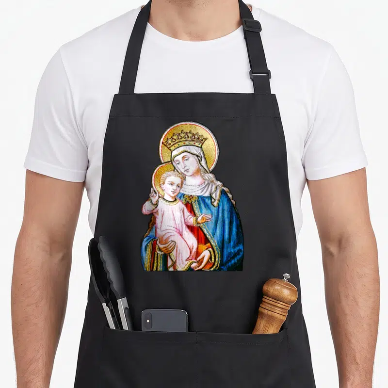 Blessed holding apron - Madonna holding Baby Jesus in blue robe with golden halo and crown — shown on a black cotton canvas apron against a white background