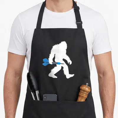 Dart bigfoot apron - White bigfoot silhouette walking right with blue and grey dart piercing midsection — shown on a black cotton canvas apron against a white background