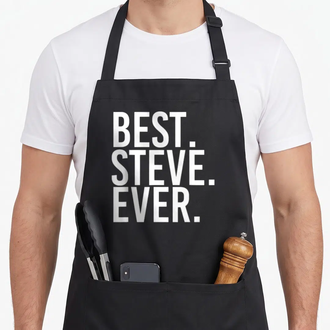 Steve father apron - White stacked text reading BEST. STEVE. EVER. in bold typography — shown on a black cotton canvas apron against a white background