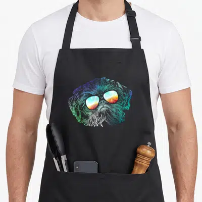 Disco groovy dog apron - Rainbow gradient dog head with sunset sunglasses in cartoon style — shown on a black cotton canvas apron against a white background