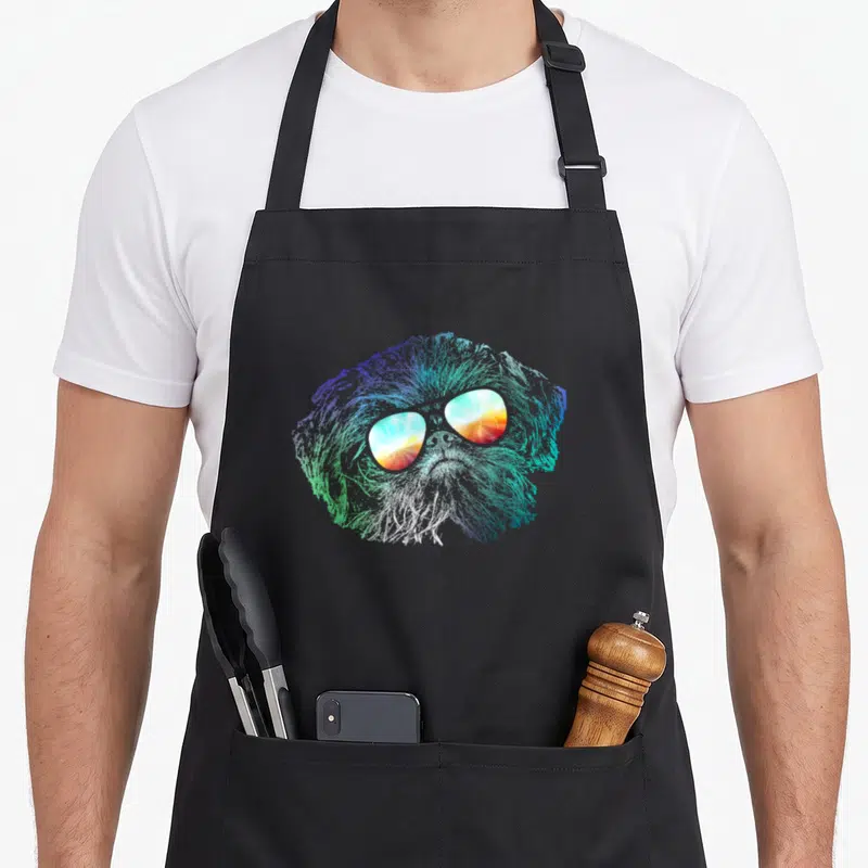 Disco groovy dog apron - Rainbow gradient dog head with sunset sunglasses in cartoon style — shown on a black cotton canvas apron against a white background