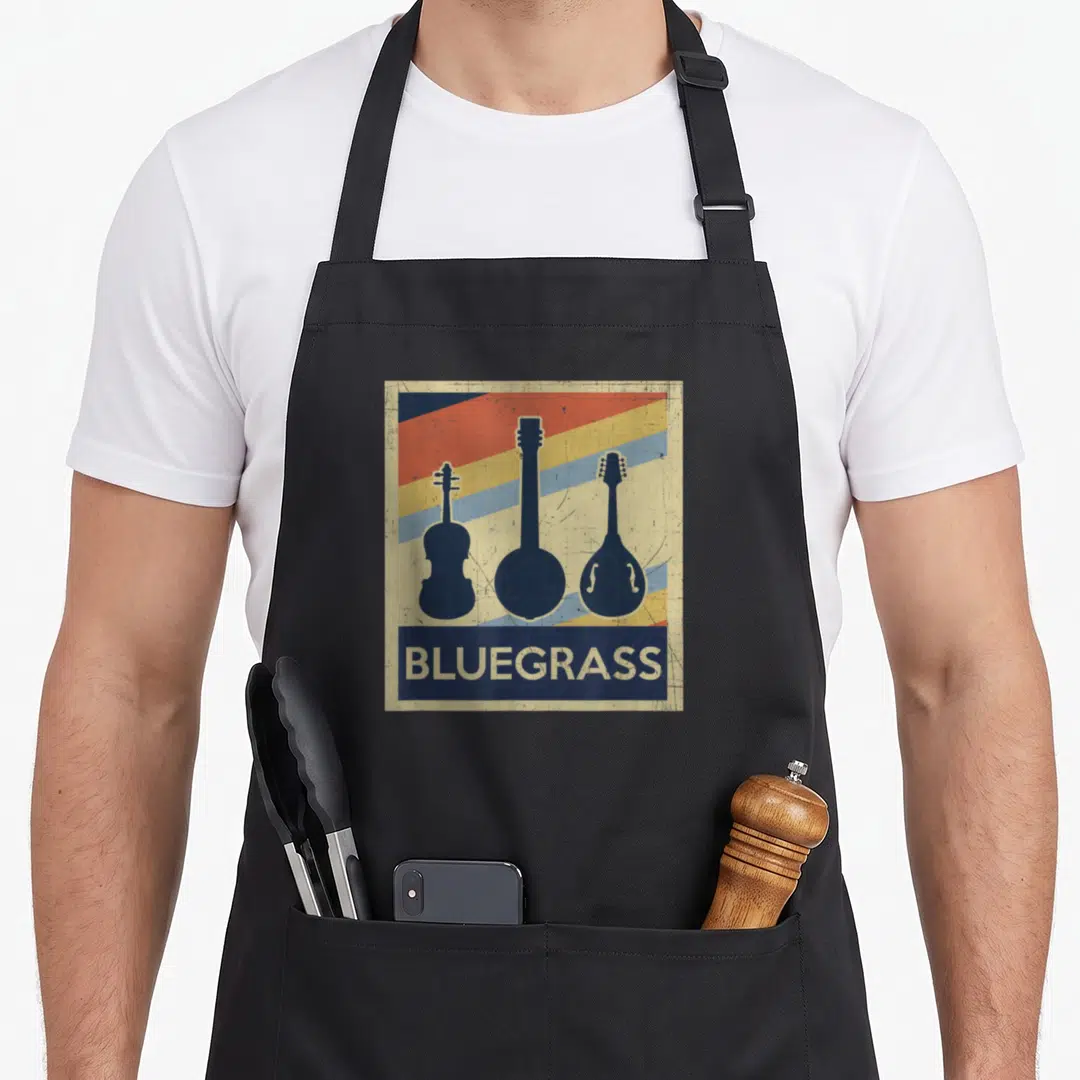 Instrument bluegrass apron - Retro poster style with three string instrument silhouettes and bluegrass text on striped — shown on a black cotton canvas apron against a white background