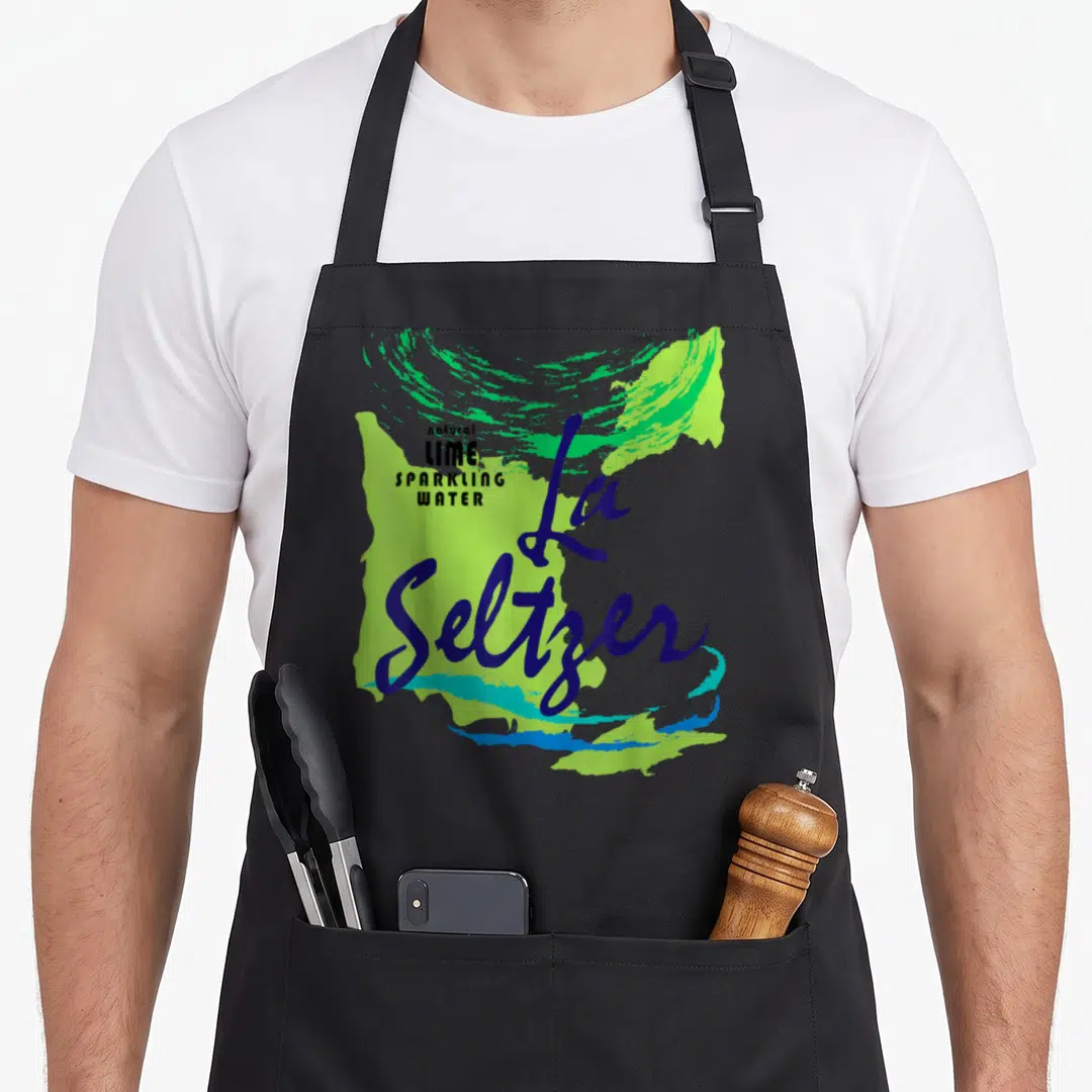 Costume lime halloween apron - La Seltzer script and natural lime sparkling water text over green teal paint splash — shown on a black cotton canvas apron against a white background