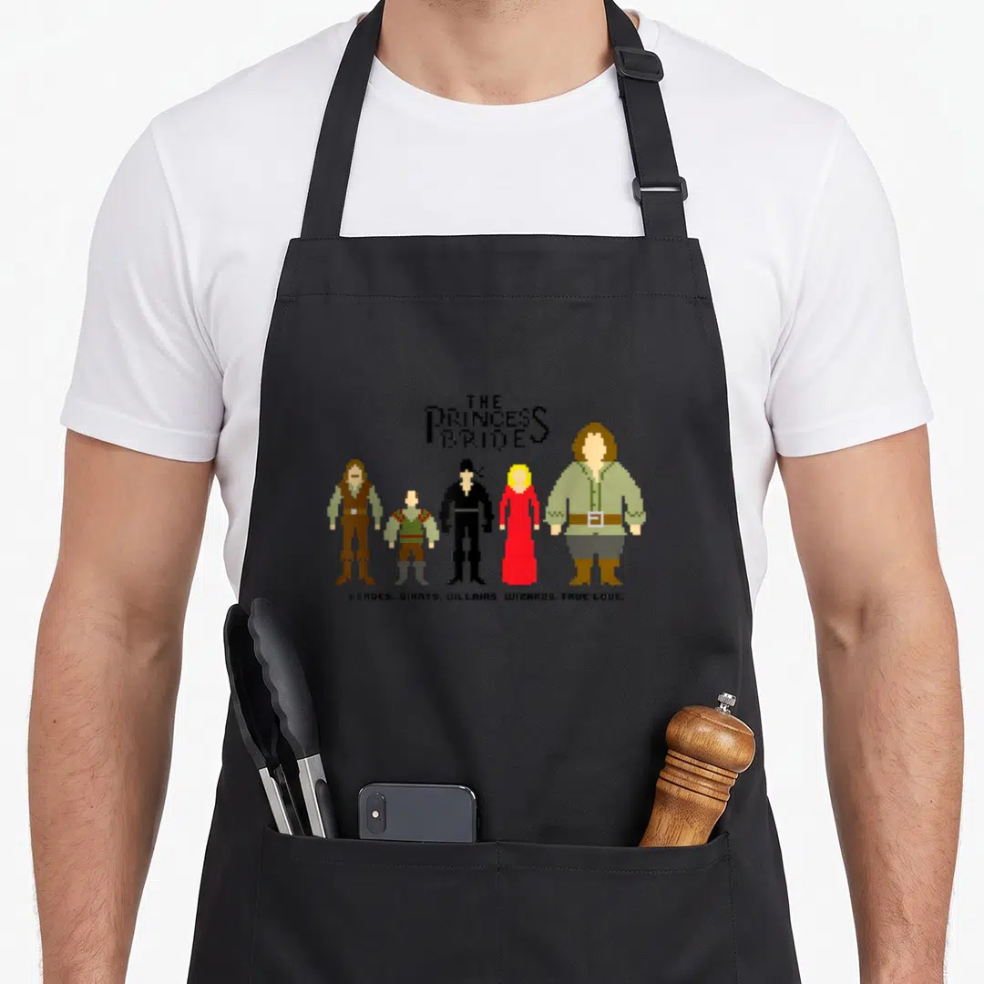 Bride princess apron - Pixel art lineup of Princess Bride characters with Heroes Giants Villains Wizards True Love text — shown on a black cotton canvas apron against a white background
