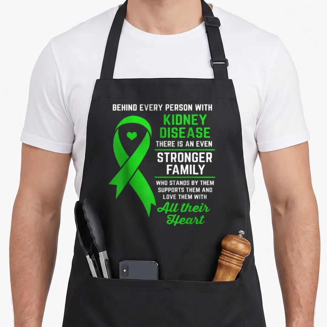 Funny support kidney disease awareness apron - Green awareness ribbon with heart and stacked white text about family — shown on a black cotton canvas apron against a white background
