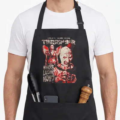Terrifier horror movie apron - Art the Clown and winged woman with Terrifier text in red and white distressed style — shown on a black cotton canvas apron against a white background