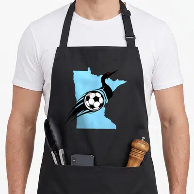 Soccer minnesota apron - Minimalist black loon over light blue Minnesota state map with soccer ball and motion lines — shown on a black cotton canvas apron against a white background