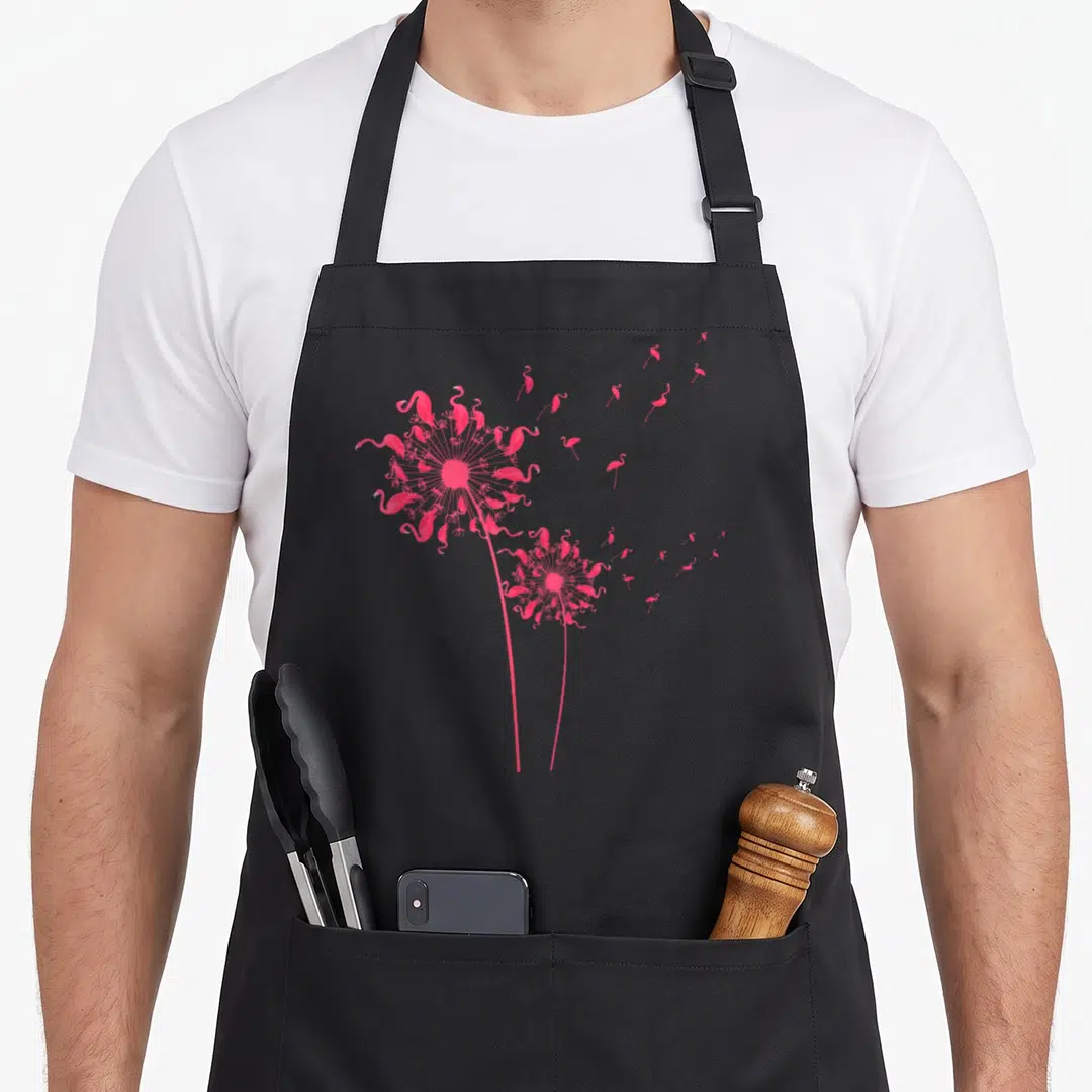 Dandelion bird apron - Two pink dandelion structures made of flamingos with some flying right — shown on a black cotton canvas apron against a white background