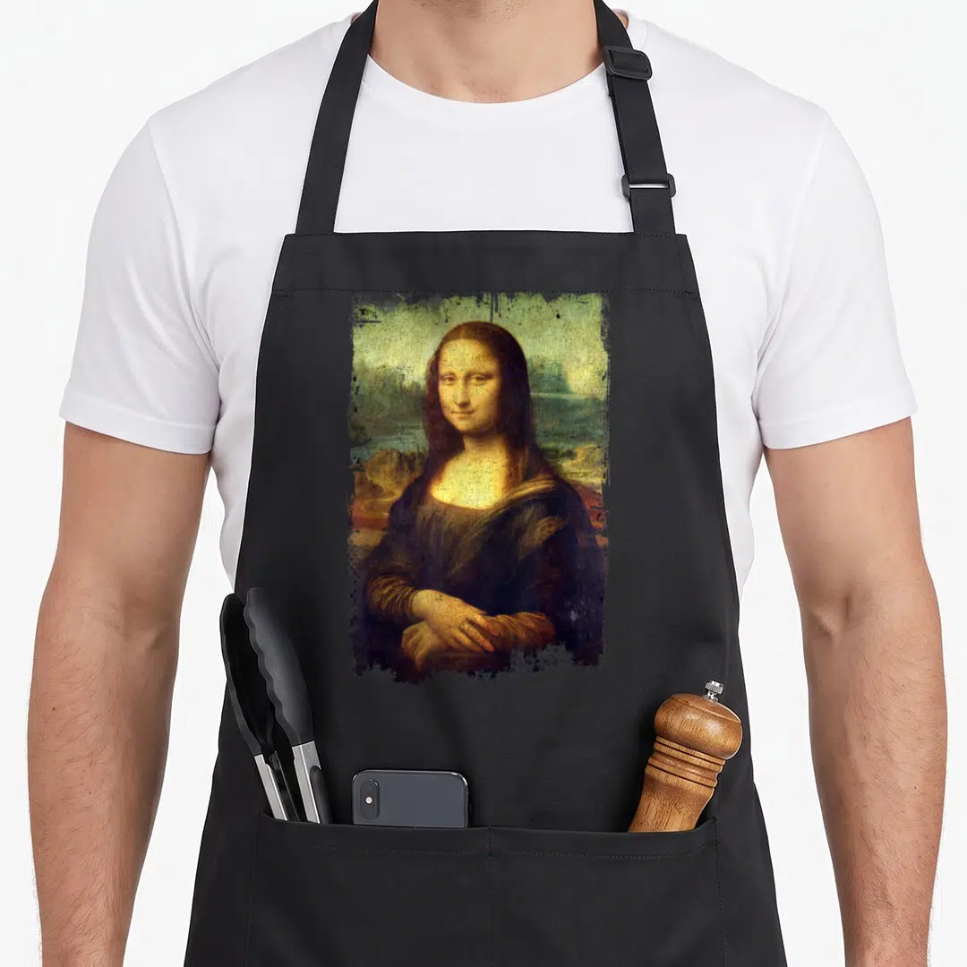 Lisa famous aprons - Distressed Mona Lisa portrait with torn edges in brown, green, yellow, and black — shown on a black cotton canvas apron against a white background
