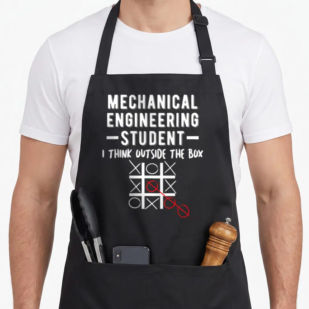 College mechanical engineer apron - White stacked text above tic-tac-toe grid with red circles extending outside the box — shown on a black cotton canvas apron against a white background