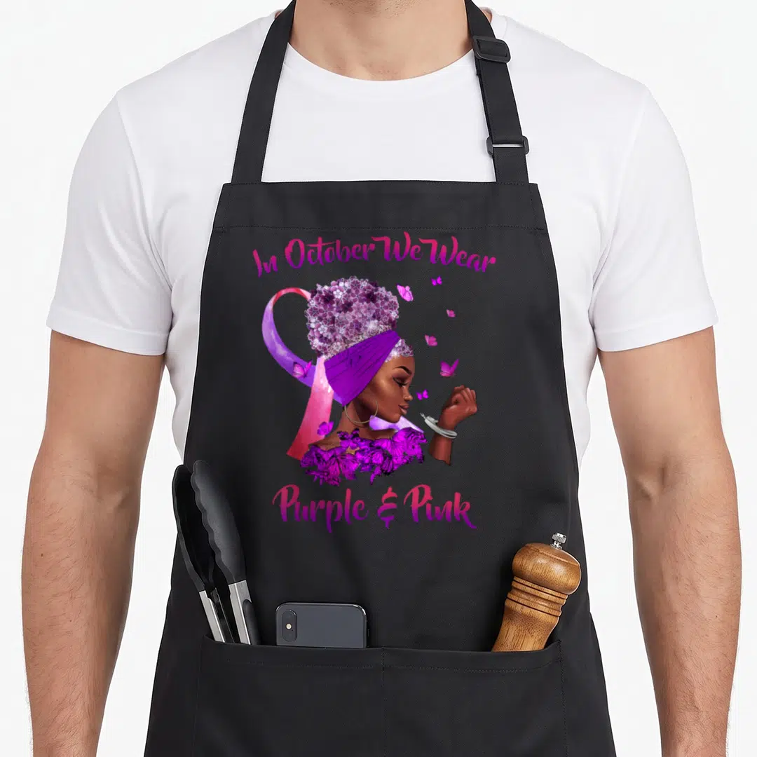 Breast cancer domestic aprons - Woman with purple pink butterflies and awareness ribbon holding raised fist — shown on a black cotton canvas apron against a white background