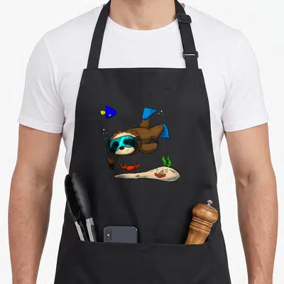 Scuba sloth apron - Cartoon brown sloth diving with blue mask and red crabs on beige sand — shown on a black cotton canvas apron against a white background