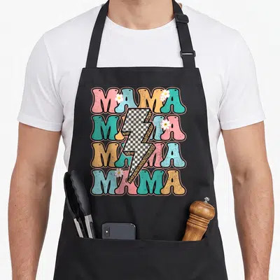 Checkered mother's day aprons - Retro MAMA text stack with checkered lightning bolt and flowers in pink cyan orange — shown on a black cotton canvas apron against a white background