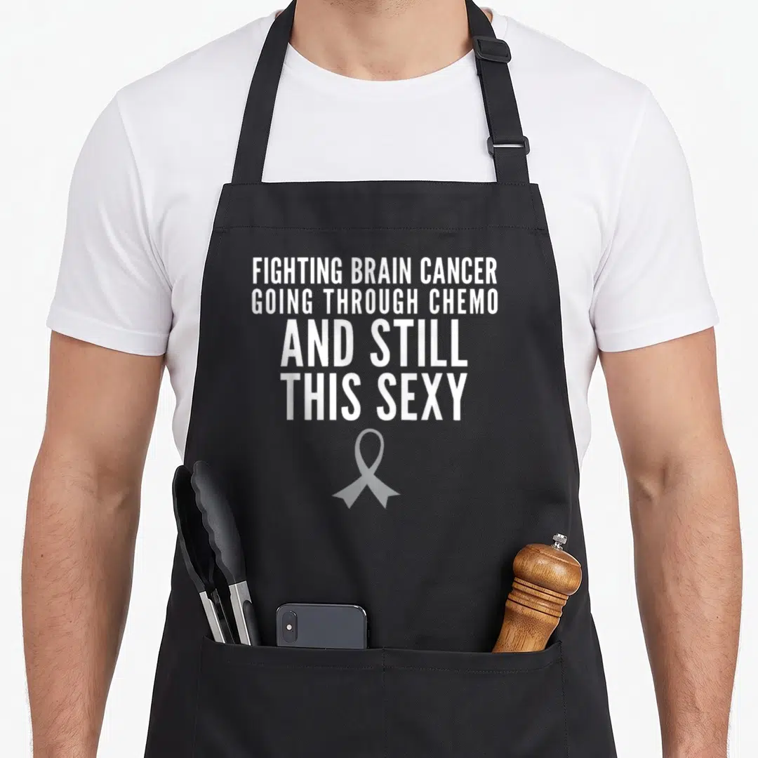 Brain cancer fighter apron - White stacked text reading Fighting Brain Cancer above a grey ribbon — shown on a black cotton canvas apron against a white background