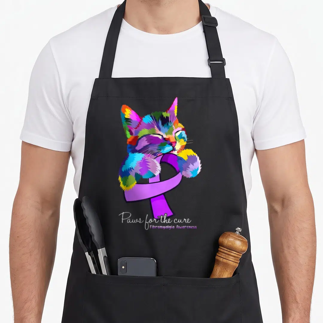 Awareness cat apron - Multicolored cartoon cat hugging purple ribbon with Paws for the cure text — shown on a black cotton canvas apron against a white background