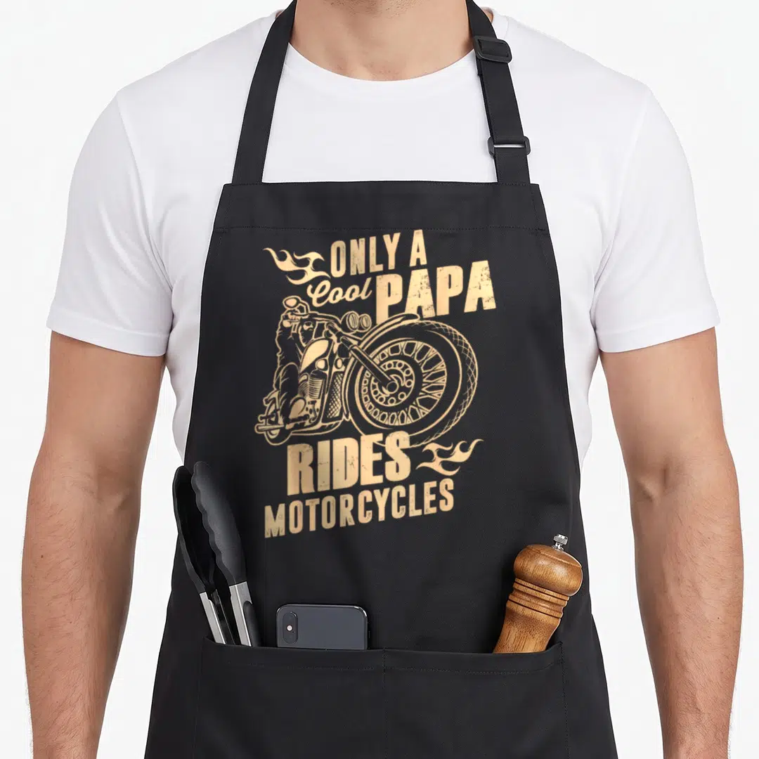 Papa motorcycle apron - Tan distressed motorcycle graphic with flames and text Only a Cool Papa Rides Motorcycles — shown on a black cotton canvas apron against a white background