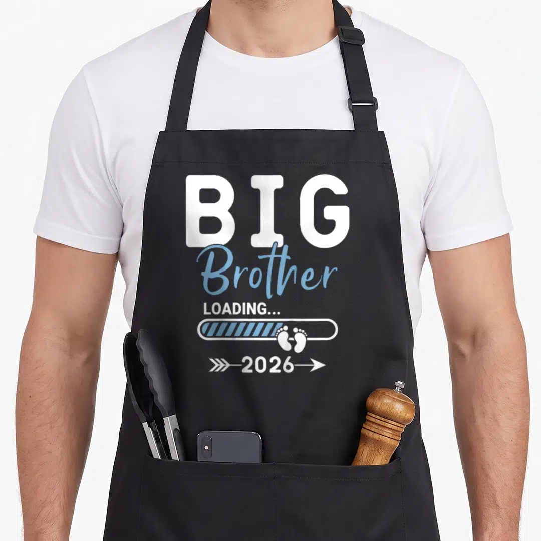 Loading brother apron - White and blue Big Brother Loading 2026 text with baby footprints in a progress bar — shown on a black cotton canvas apron against a white background