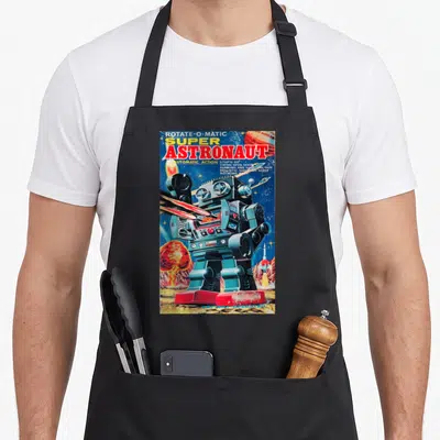 Astronaut robot apron - Vintage robot firing lasers with text listing automatic action and shooting gun features — shown on a black cotton canvas apron against a white background
