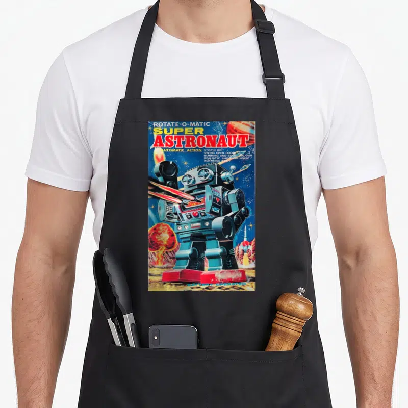 Astronaut robot apron - Vintage robot firing lasers with text listing automatic action and shooting gun features — shown on a black cotton canvas apron against a white background