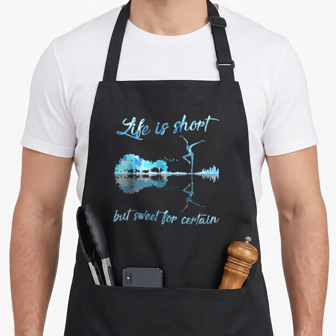 But shortstop apron - Blue watercolor ballerina and trees with Life is short text and mirrored reflection — shown on a black cotton canvas apron against a white background