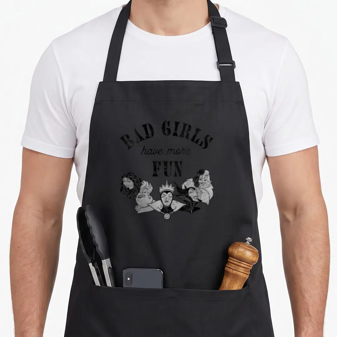 Villain crazy mouse lady apron - BAD GIRLS have more FUN text above four distressed villain heads in black and white — shown on a black cotton canvas apron against a white background